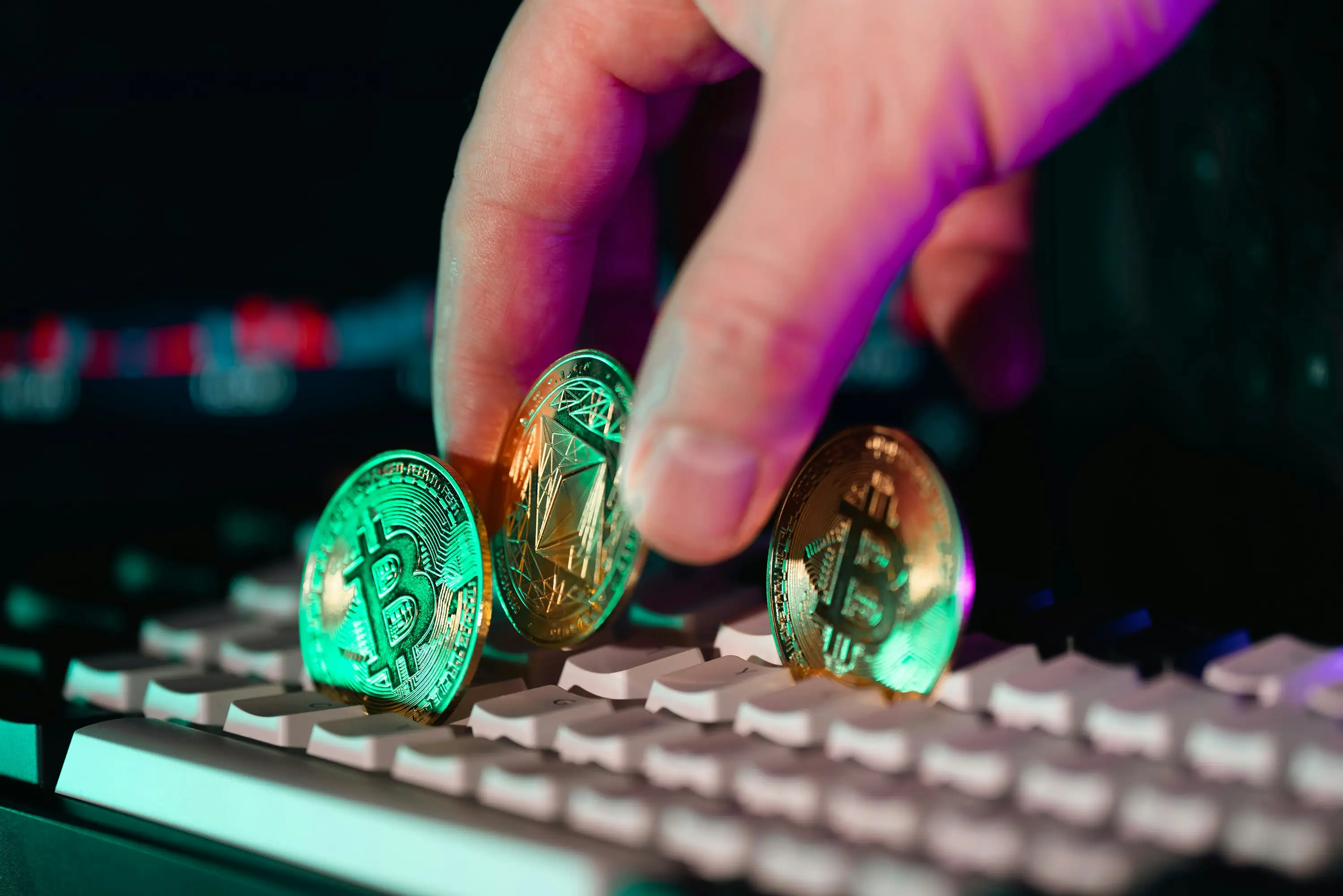 Hånd som plasserer kryptomynter på et tastatur