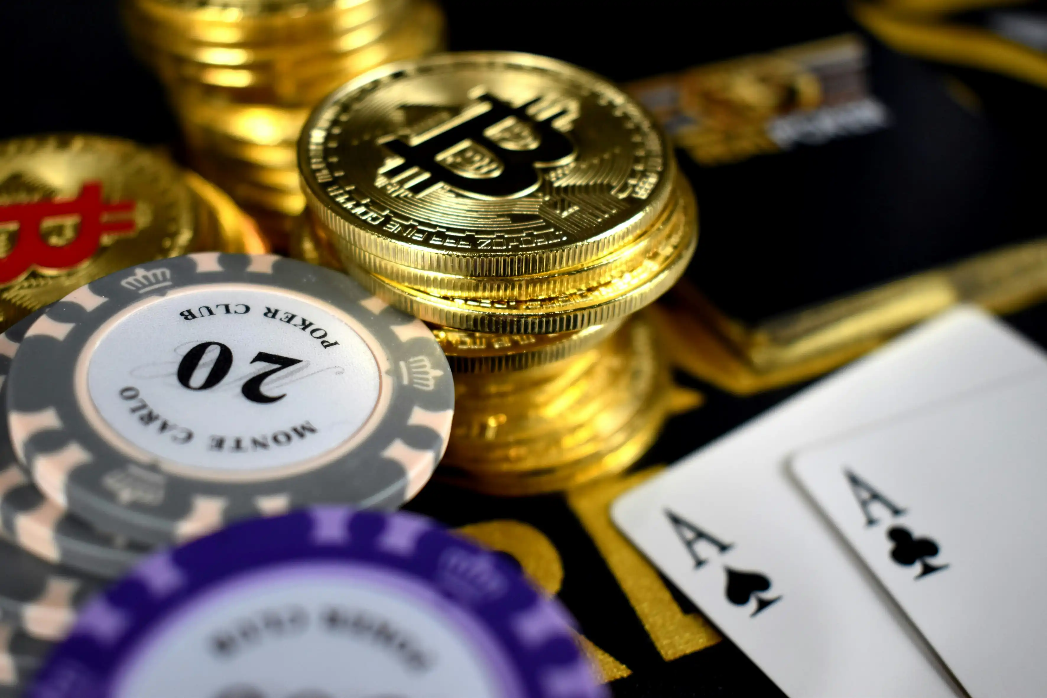 Bitcoin-mynt, pokerbrikker og spillkort på casinobord