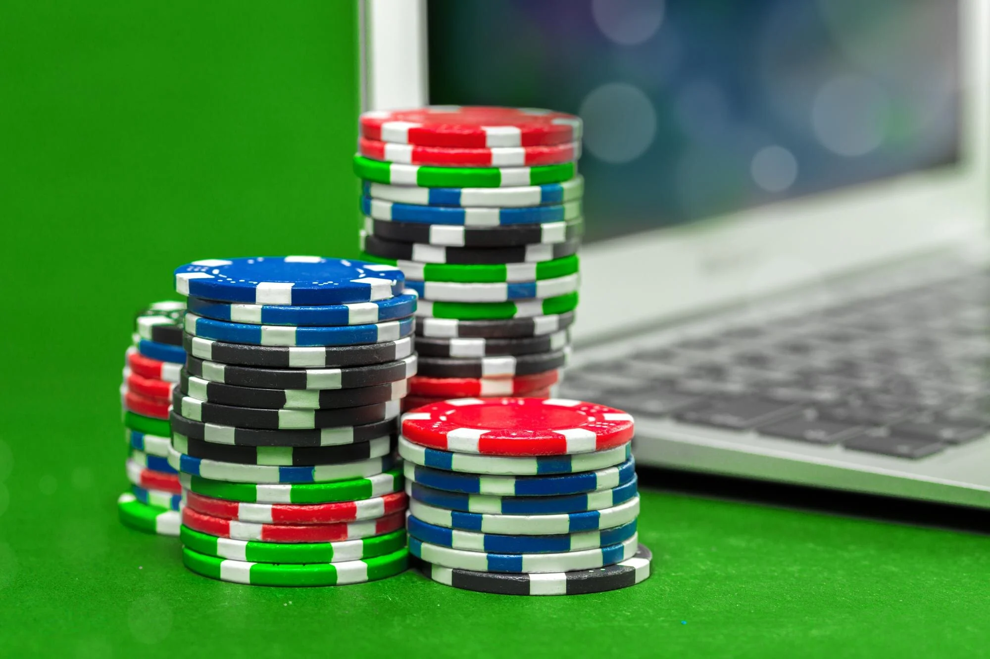 Stablede pokerbrikker ved en bærbar datamaskin
