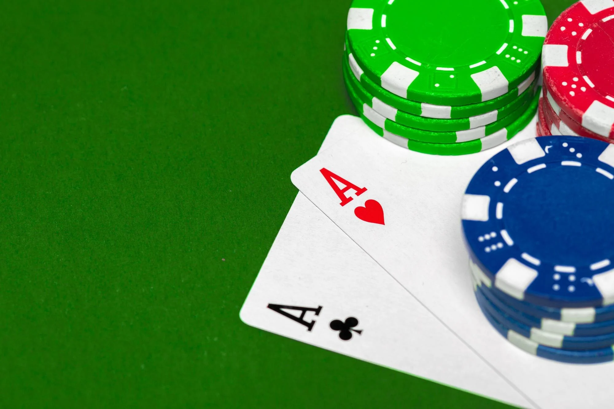 Pokerbrikker og ess på grønt casinobord